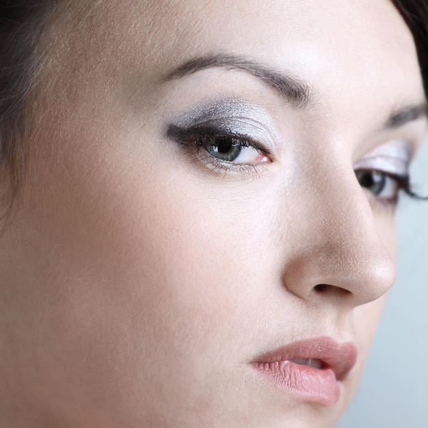 Closeup uma jovem com maquiagem diária olha para cima