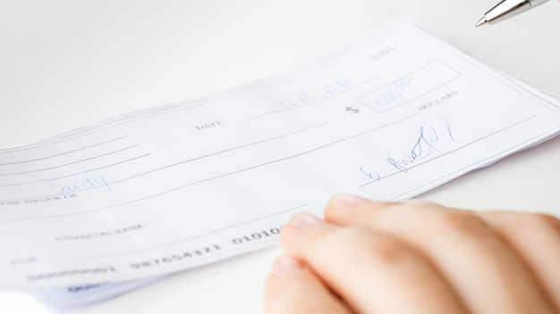 Closeup vista de cheque bancário preenchido e assinado.