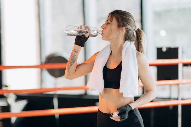 Closeup vista de uma jovem mulher tendo uma pausa após treinamento duro pelo saco de boxe