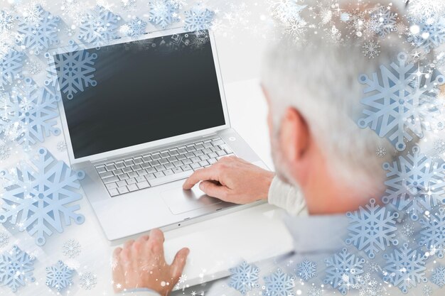 Closeup vista traseira de um homem de cabelos grisalhos usando laptop na mesa contra a neve