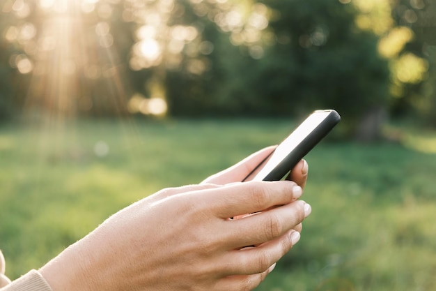 Closeup weibliche Hände mit Smartphone Natur Hintergrund Frau Person Handy Sonnenuntergang im Freien