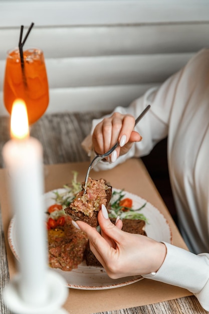 Closeup weibliche Hände verbreiten Tartar mit Brot