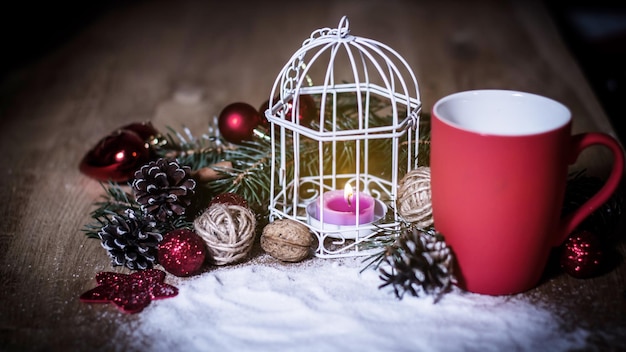 Closeupred Tasse und Kerze am Weihnachtsfeiertagstisch