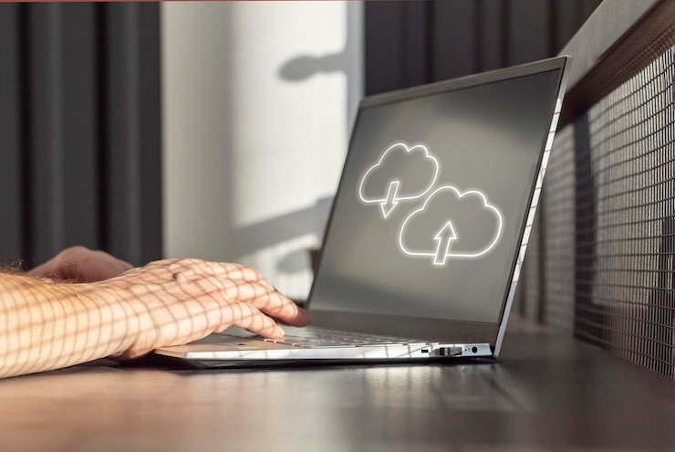 Foto cloud-computing mann, der einen laptop zum hochladen von speichern, herunterladen oder teilen von dateien und daten online verwendet männliche hände auf der computertastatur in der nähe