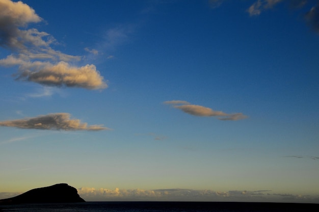 Cloudscape, nuvens coloridas ao pôr do sol perto do oceano