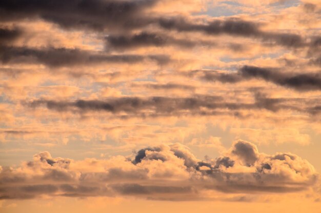 Cloudscape, nuvens coloridas ao pôr do sol perto do oceano