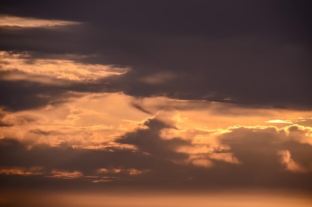 Cloudscape, nuvens coloridas ao pôr do sol perto do oceano