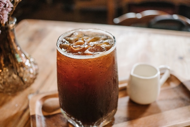 clouse encima de café fresco del hielo (americano frío) en fondo de la cafetería