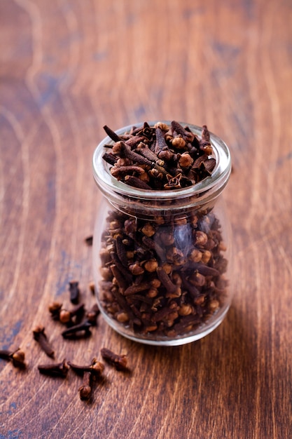 Cloves. Tempero seco para cozinhar e bebidas em um fundo de madeira velho simples. Foco seletivo