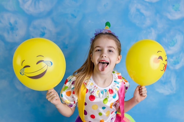 Foto clown de criança engraçado brincando contra uma parede brilhante 1o de abril conceito de dia dos tolos conceito de aniversário