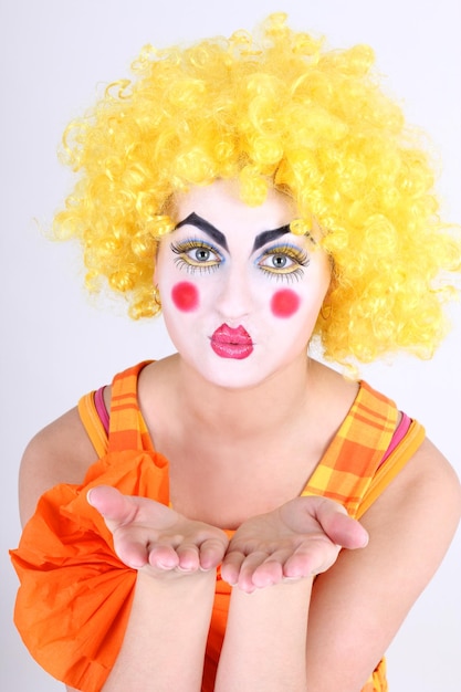 Foto clown im bunten kostüm mit make-up, das hände zeigt