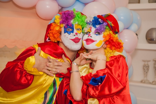 Clownjunge mit Clownmädchen, das sich bei der Feier amüsiert Ausdruck von Emotionen
