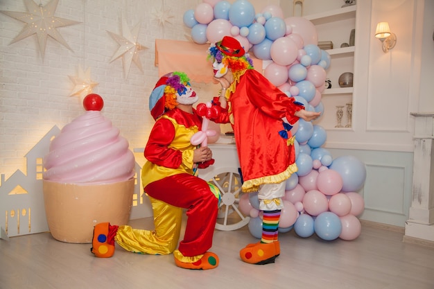 Clownjunge mit Clownmädchen, das sich bei der Feier amüsiert Ausdruck von Gefühlen
