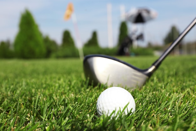 Foto club de golf y pelota sobre un césped verde