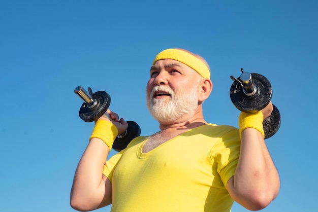 Club de salud para ancianos deportistas mayores levantando pesas en el centro deportivo
