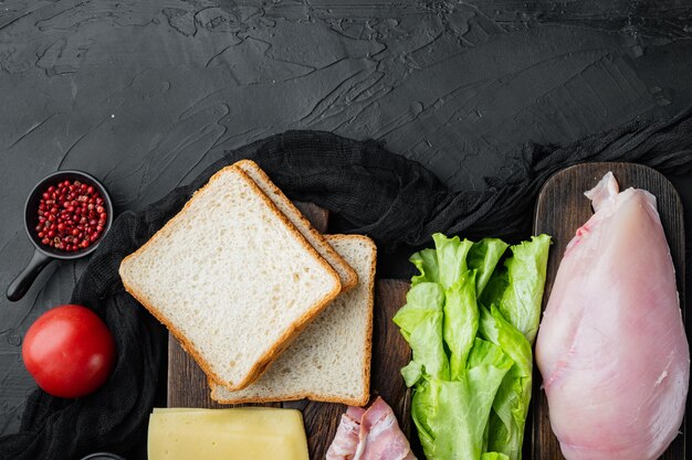 Club sándwich con ingredientes frescos, sobre fondo negro, vista superior con espacio para copiar texto