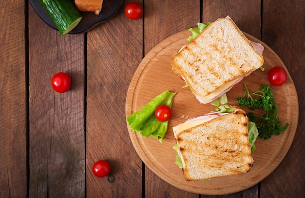 Club sandwich mit käse, gurke, tomate, schinken und eiern.