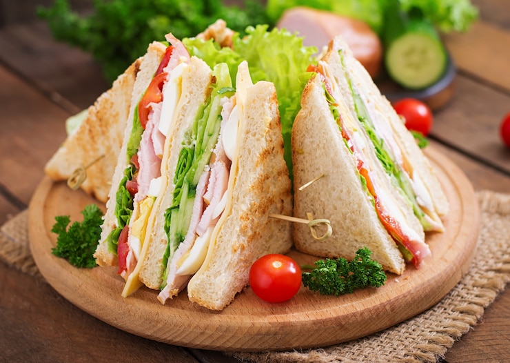 Foto club sandwich mit käse, gurke, tomate, schinken und eiern.