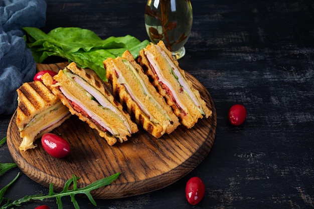 Club-Sandwich mit Schinken-Käse-Tomaten und Salat Gegrilltes Sandwich mit getrockneten Tomatenbrot