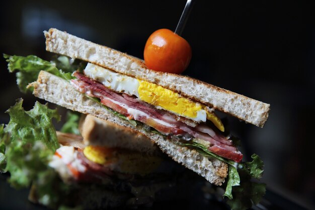 Club sándwiches sobre fondo de madera con luz mística