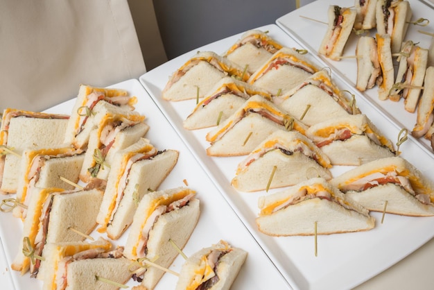 Club-sandwiches werden für das catering vor ort geliefert. leckere frische snacks für große gesellschaft.