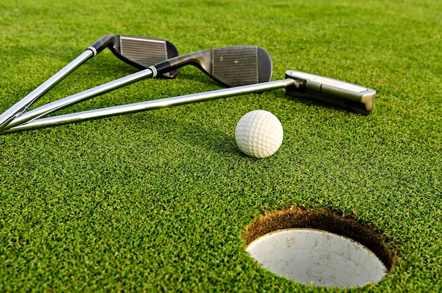 Clube de golfe e bola no campo