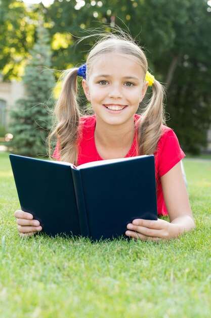 Clube de leitura de verão Garota feliz leu livro na grama verde Lista de leitura de verão Férias de verão Férias escolares Recreação e lazer Leia mais neste verão