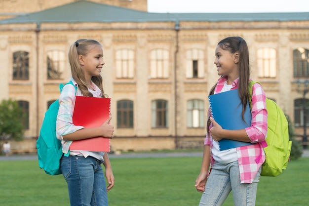 Clube escolar. educação moderna. ensino particular. adolescentes com mochilas. elegantes alunas sorridentes. fundo de construção de escola de meninas. ajude seus filhos a recuperar o atraso ou progredir sem a escola de verão.