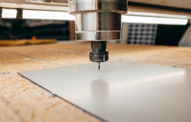 CNC-Bohrmaschine arbeitet mit Metallplatte Closeup