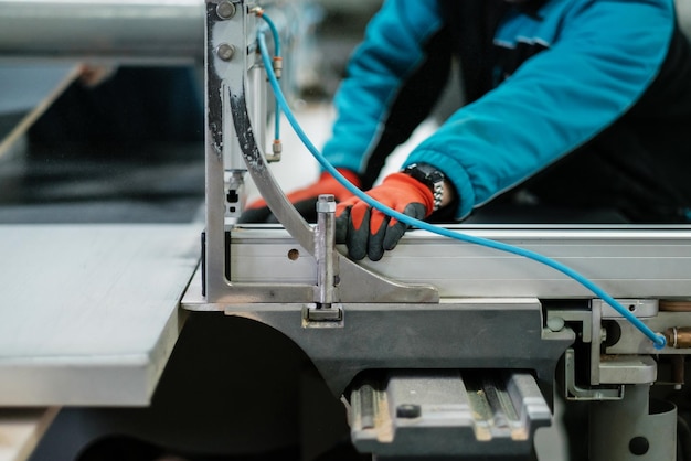 Cnc-Kreissäge Sägen von Spanplatten Verfahren zur Herstellung von Schrankmöbeln Nahaufnahme Arbeiter mit Handschuhen an der Maschine