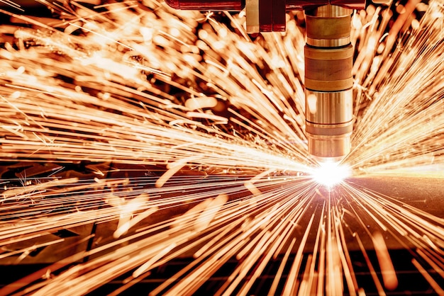 CNC Laser Plasmaschneiden von Metall, moderne Industrietechnik. . Geringe Schärfentiefe. Achtung - Authentisches Schießen unter anspruchsvollen Bedingungen. Ein bisschen Körnung und vielleicht verschwommen.