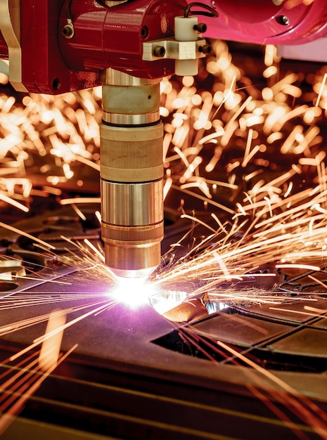 CNC-Laser-Plasmaschneiden von Metall, moderne Industrietechnologie. Geringe Schärfentiefe. Achtung - authentisches Schießen unter schwierigen Bedingungen. Ein bisschen Körnung und vielleicht verschwommen.