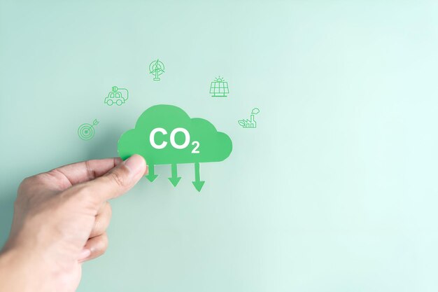 CO2-Symbol in der Hand in einem Holzblock Reduzierung von Kohlenstoff oder CO2 in der Atmosphäre für nachhaltige Luft und grüne Energie