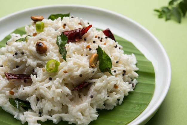 Coalhada de arroz ou Dahi Bhat OU Chawal com folha de curry, amendoim e pimenta-malagueta servida em uma tigela sobre um fundo temperamental. Foco seletivo