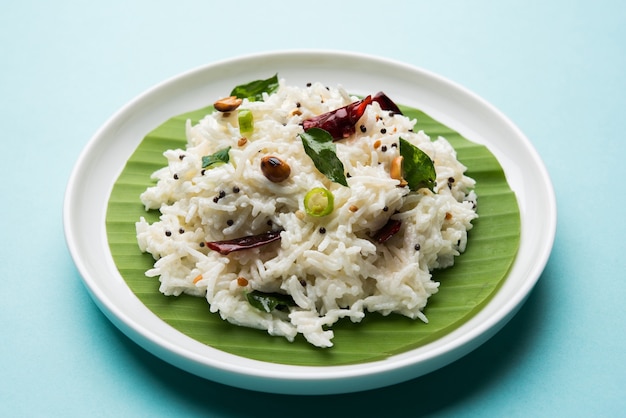 Coalhada de arroz ou Dahi Bhat OU Chawal com folha de curry, amendoim e pimenta-malagueta servida em uma tigela sobre um fundo temperamental. Foco seletivo
