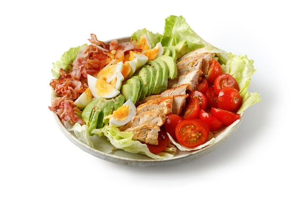 Cobb-Salat mit Speck Avocado Tomate gegrillte Hühnereier isoliert auf weißem Hintergrund Gesunde Ernährung