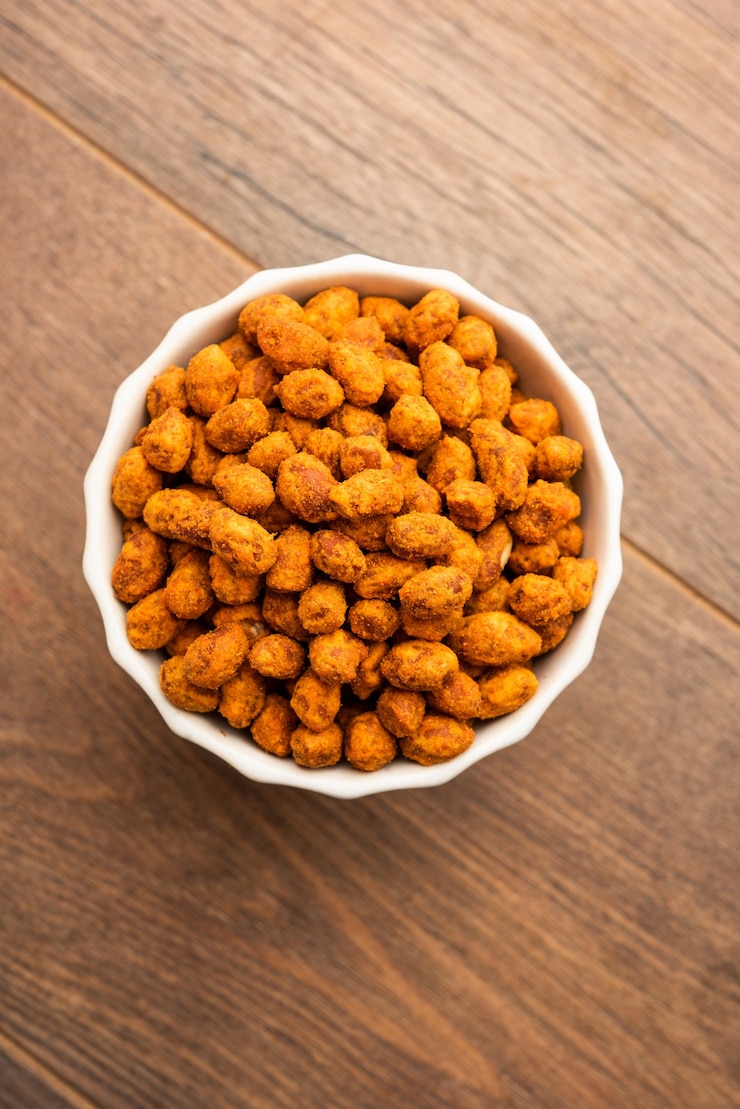 Foto coberto de besan indiano crocante e picante de masala amendoim ou mungfali servido em uma tigela ou prato