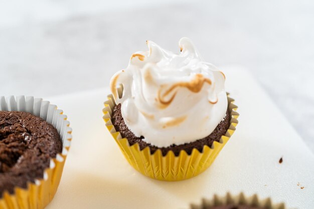 Cobertura de cupcakes s'mores com cobertura de merengue branco.