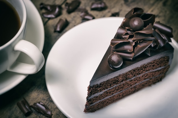 cobertura de pastel de chocolate con rizo de chocolate sobre fondo de madera, tono vintage