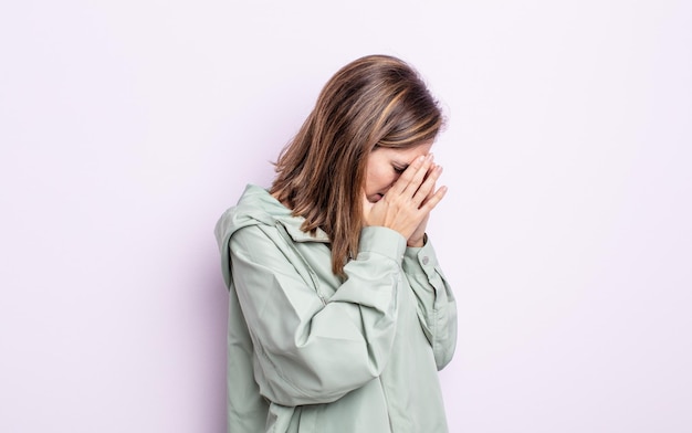 Cobrindo os olhos com as mãos com um olhar triste e frustrado de desespero chorando vista lateral