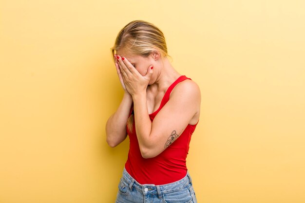 Cobrindo os olhos com as mãos com um olhar triste e frustrado de desespero chorando vista lateral