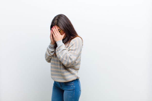 cobrindo os olhos com as mãos com um olhar triste e frustrado de desespero, chorando, vista lateral