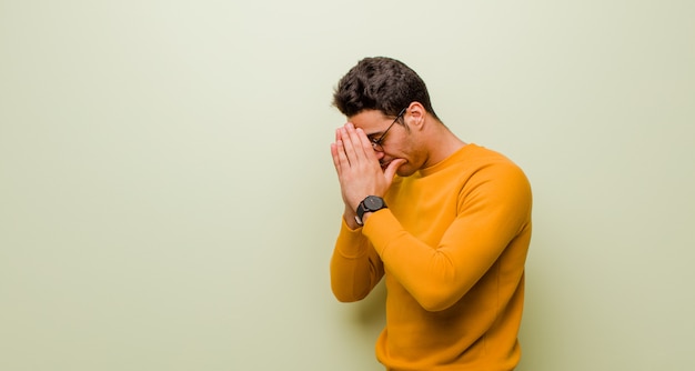 Cobrindo os olhos com as mãos com um olhar triste e frustrado de desespero, chorando, vista lateral