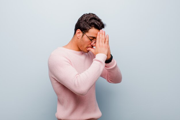 cobrindo os olhos com as mãos com um olhar triste e frustrado de desespero, chorando, vista lateral