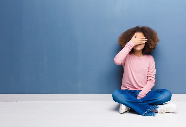 cobrindo os olhos com uma mão sentindo medo ou ansiedade, imaginando ou esperando cegamente por uma surpresa