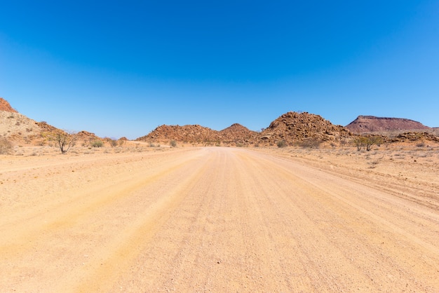 Cobrir a estrada 4x4 que cruza o deserto colorido em Twyfelfontein, no majestoso Damaraland Brandberg, Namíbia, África.