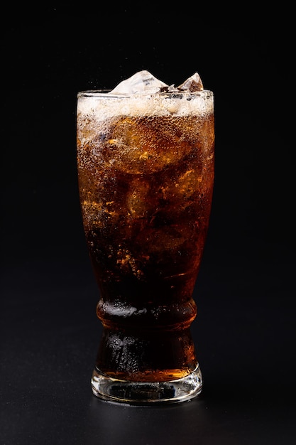 Coca-cola em copo com cubos de gelo transparentes isolados em fundo preto