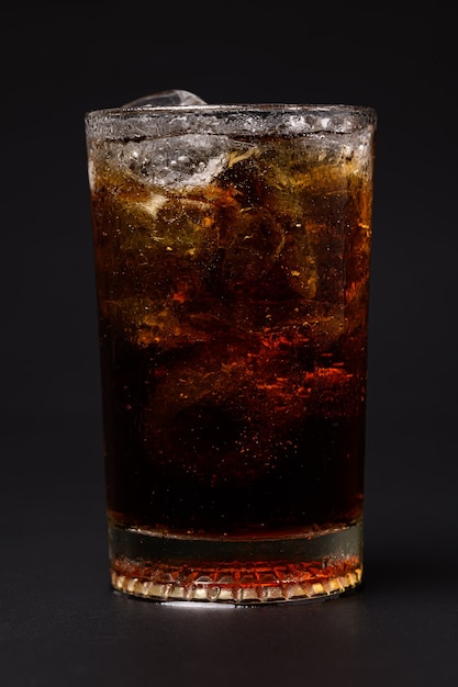 Coca-cola em vidro com cubos de gelo transparentes isolados em fundo preto