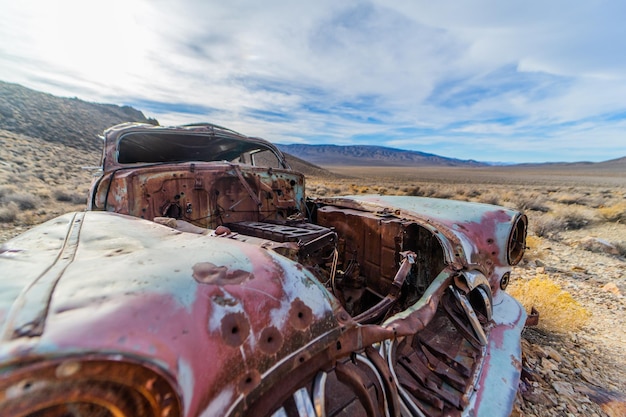 Foto coche abandonado en tierra contra el cielo