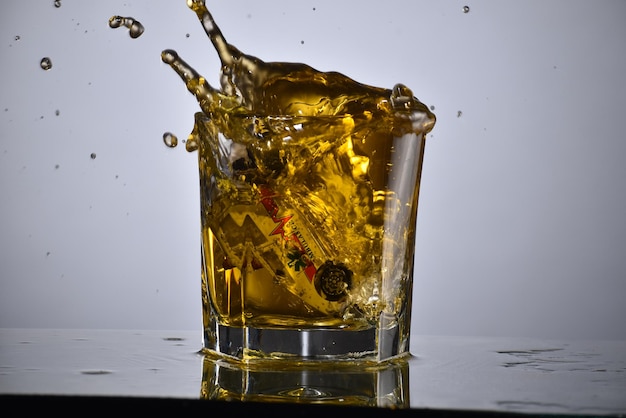 Coche ahogado en vidrio de alcohol, concepto de bebida y conducción